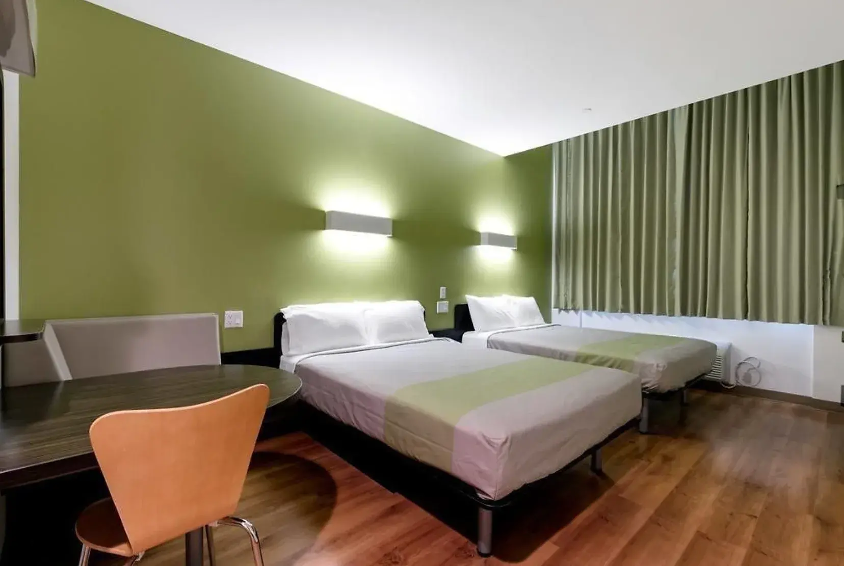 Feather Factory Family Room with two beds, table and green curtains