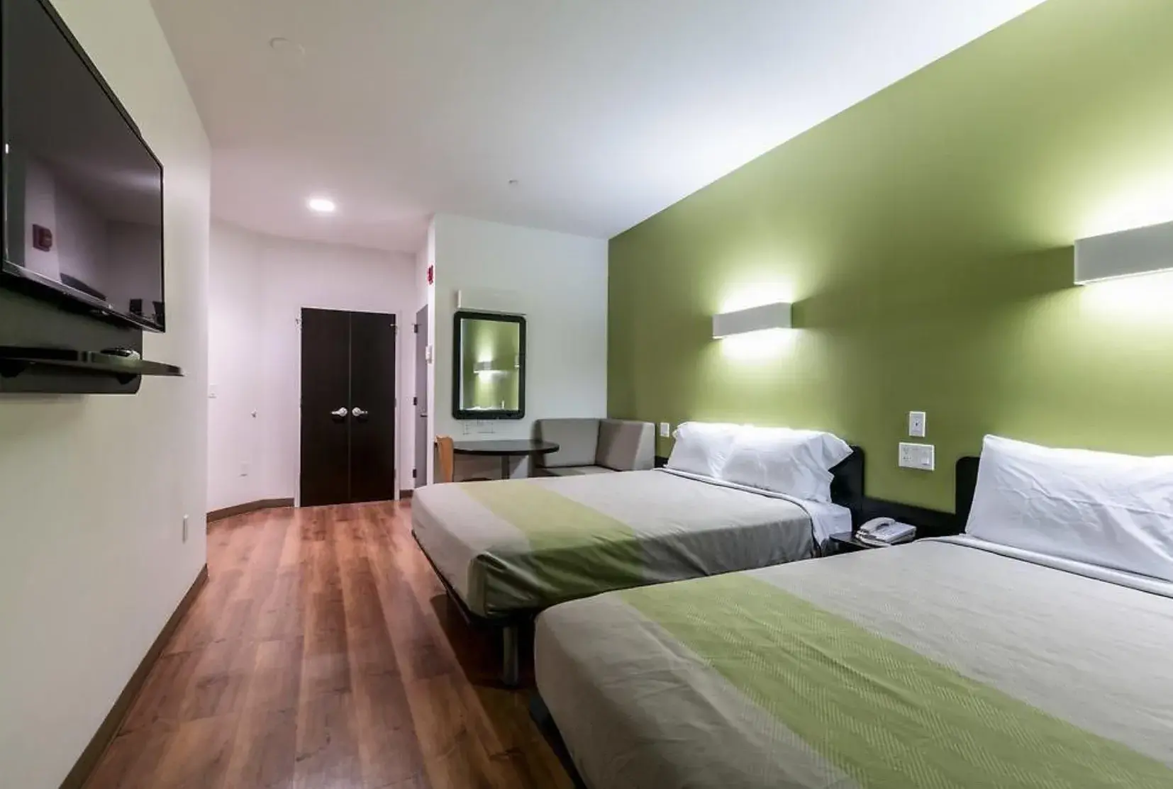Queen Room with Two Queen Beds, green wall and sofa corner