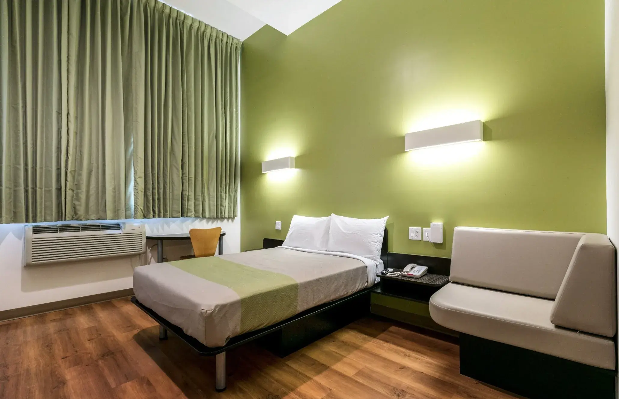 Feather Factory Hotel room with a double bed, upholstered bench and desk by the window