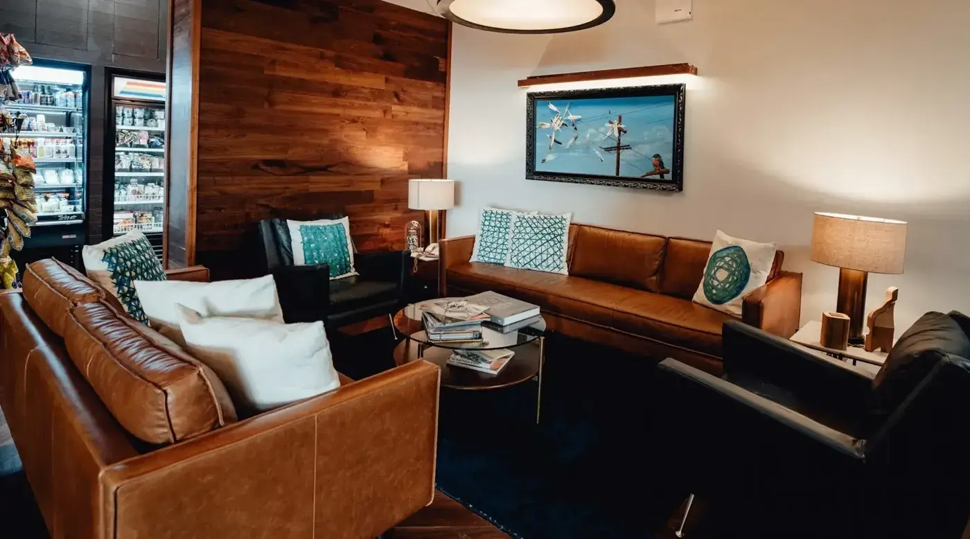 Lounge with leather sofas, armchairs and the hotel shop in the background
